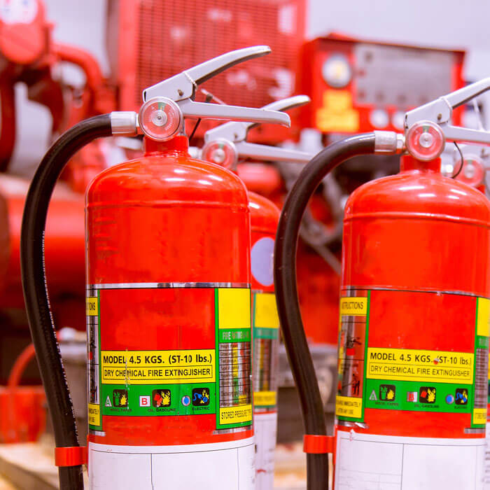 Red Class D fire extinguishers with dry chemical labels placed in an industrial area in Phoenix, AZ